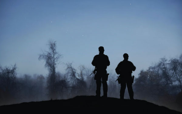 Two security personnel standing guard at dawn Two security personnel standing guard at dawn
