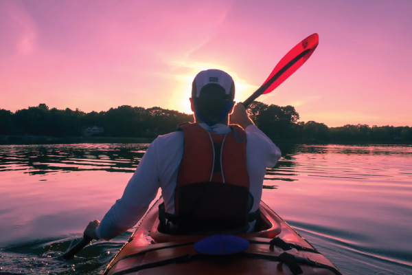 man kayaking at sunset