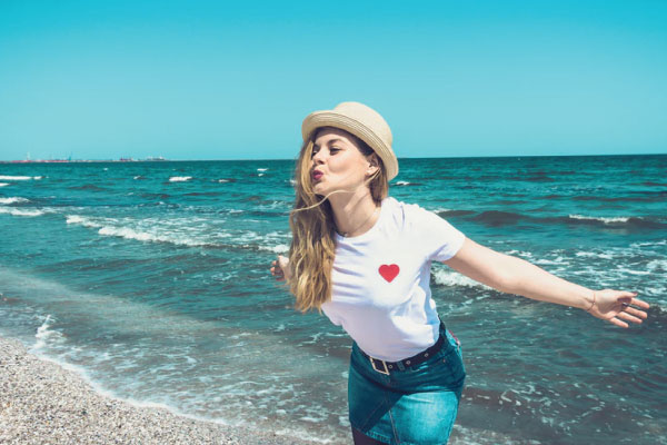 Woman poses on beach during budget travel