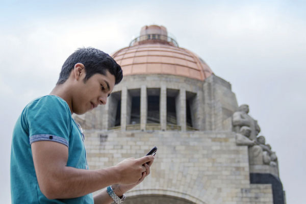 Man in front of government building on his phone