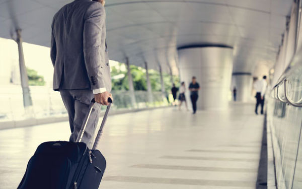 A businessman walking through an airport with luggage