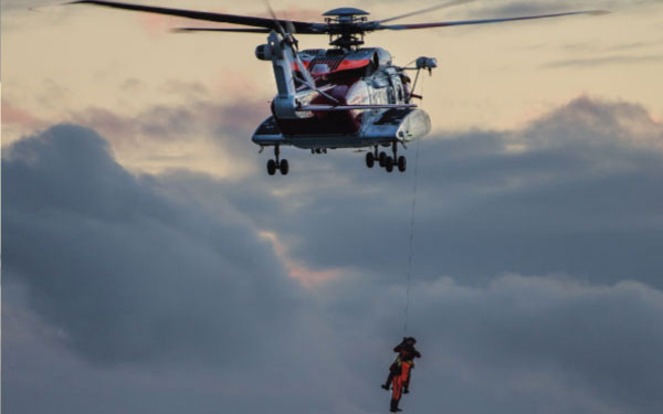 A rescue helicopter pulling up a person