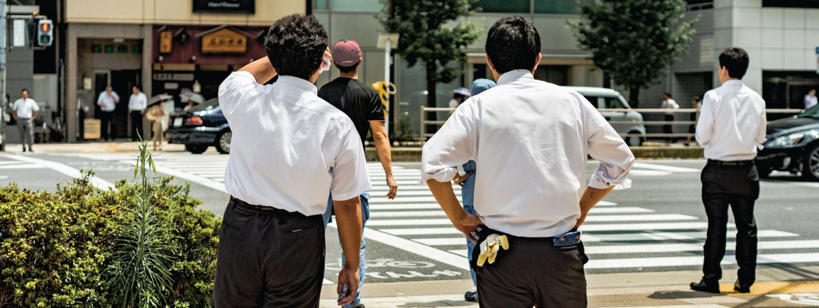 Two Business Men On A Busy Sidewalk Looking Across The street