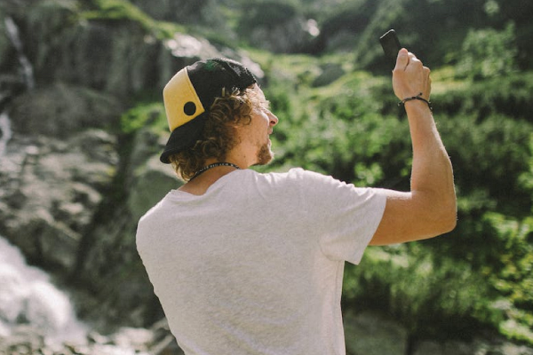 Man Holding SOS device during hike